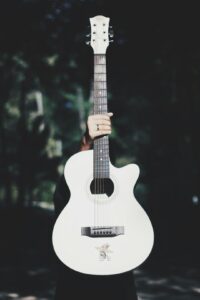Photo by frame harirak person holding white acoustic guitar